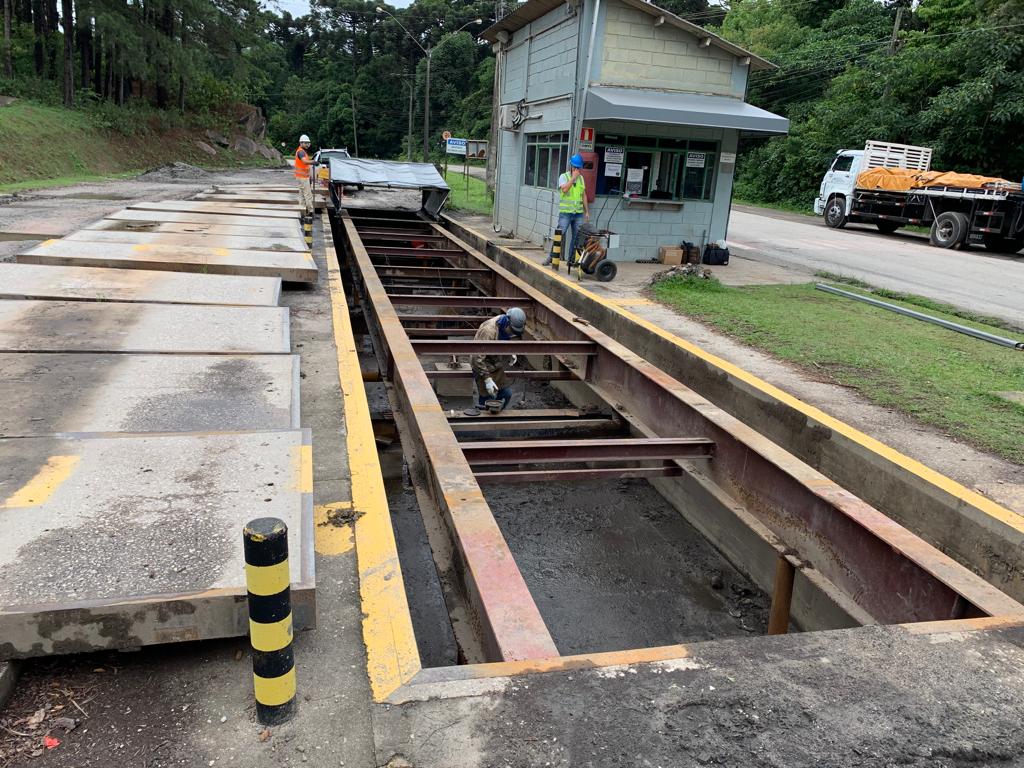 Equipe técnica em operação de manutenção de balança rodoviária